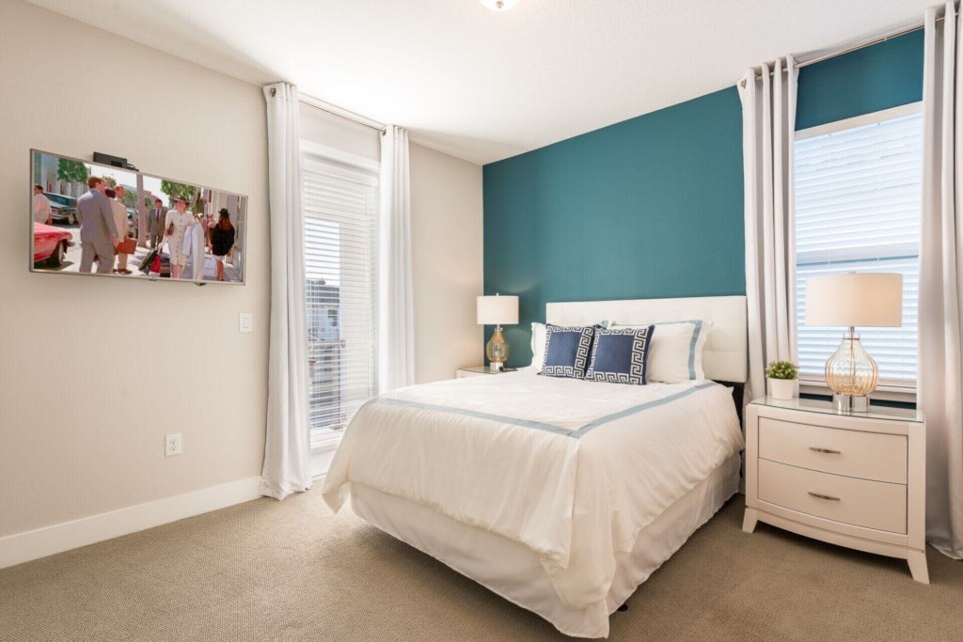 A bedroom with a bed, nightstands, a lamp, and a painting on the wall.