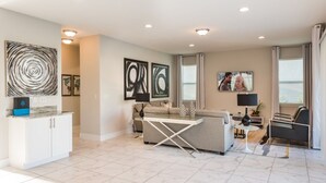 A modern living room with a sofa, coffee table, and artwork on the walls. - Villa in Encore Resort at Reunion 2979 (Kissimmee)