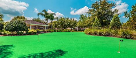 Un campo de golf con un fairway verde y bien cuidado, un pabellón y un club de campo al fondo.