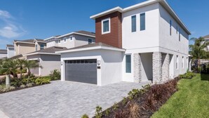 A modern two-story house with a garage, stone accents, and a well-maintained lawn.