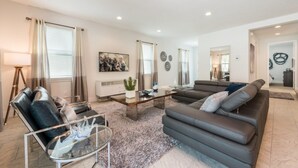A modern living room with a grey sofa, a glass coffee table, and a floor lamp.