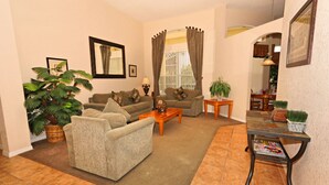 A living room with two sofas, a coffee table, a side table, and a potted plant. - Perfect 5 Bed Villa for Rent on Highlands Reserve Resort, Villa Orlando 1450 (Davenport)