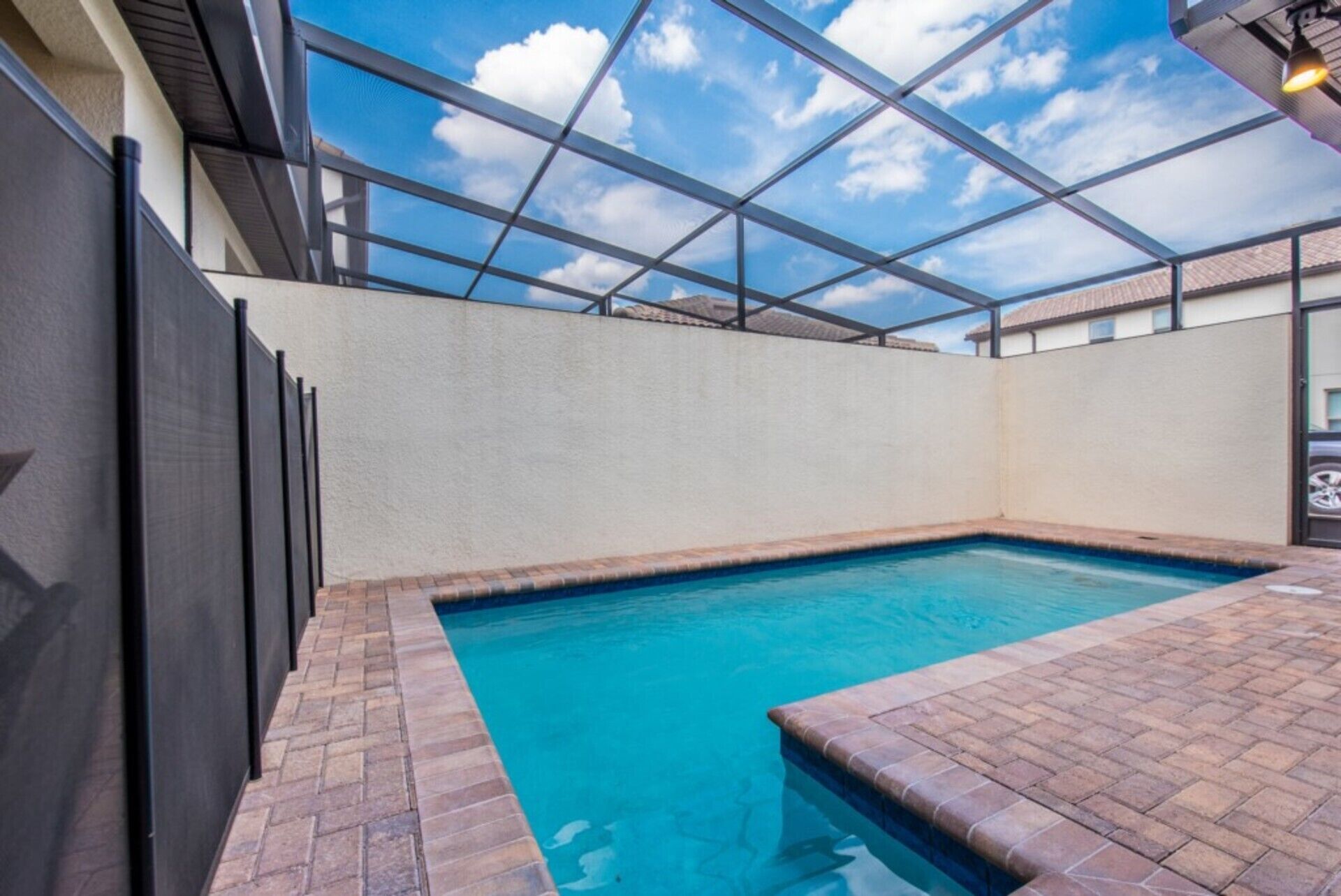 Une piscine intérieure dotée d’un plafond en verre transparent, entourée de murs et recouverte d’un sol en briques.