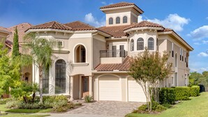 A large, two-story house with a tiled roof, multiple windows, and a garage. - Villa in Reunion Resort & Spa 1336 (Kissimmee)
