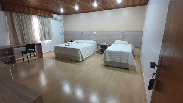 Habitación de hotel con dos camas, un escritorio y una silla.