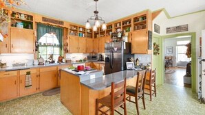 Una cocina con armarios de madera, una isla central y una araña.