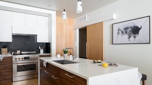 Una cocina moderna con una isla central, electrodomésticos de acero inoxidable y armarios de madera.
