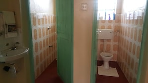 A bathroom with a sink, toilet, and green door. - By Grace apartment near sportman arms,hosted by regina (Nanyuki)
