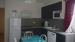 A compact kitchen with a refrigerator, microwave, coffee maker, and sink. - T2 1st floor of the villa of the sea (Hyères)