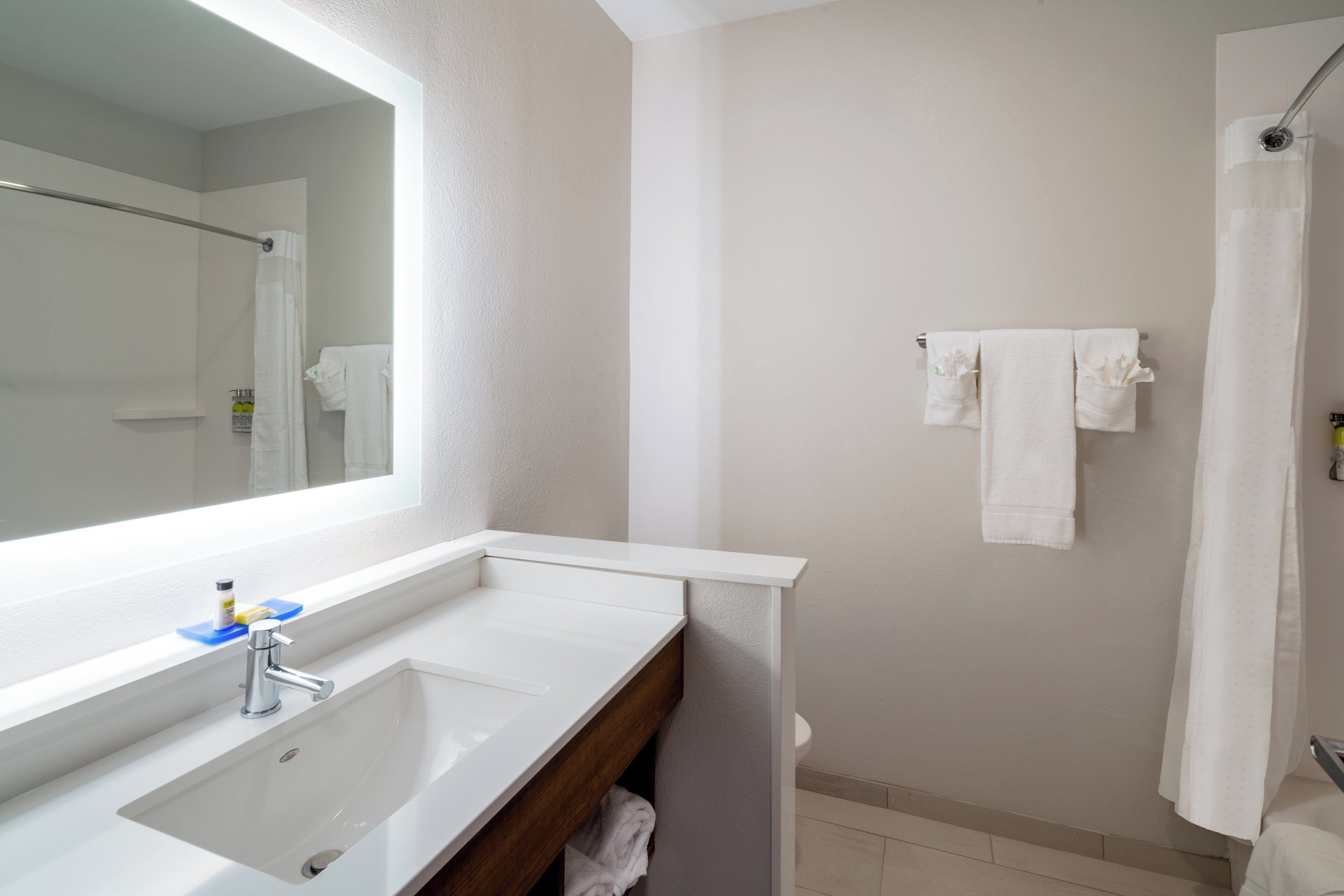 A bathroom with a white sink, a mirror, and a shower curtain.
