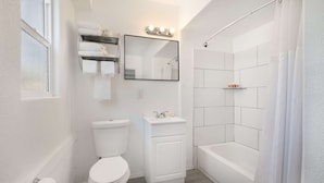 A modern bathroom with a toilet, sink, and bathtub.