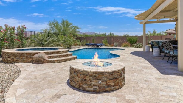 A backyard with a swimming pool, a fire pit, and outdoor furniture. - Modern home in Estrella Mtn Ranch - refreshing Pool & Spa / Fire pit / Mtn Views (Goodyear)