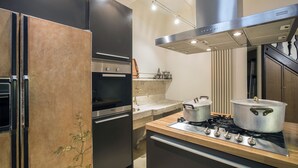 A modern kitchen with stainless steel appliances, a built-in oven, and a gas stove.