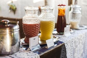 A beverage station with clear glass dispensers and metal containers. - Pousada Carmo (Fernando de Noronha)