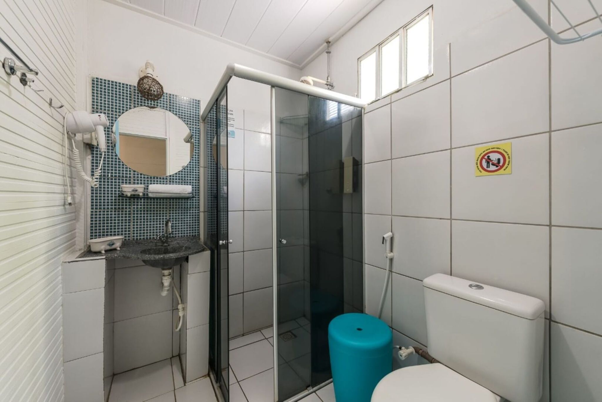 A bathroom with a glass shower enclosure, a sink with a mirror, and a toilet.