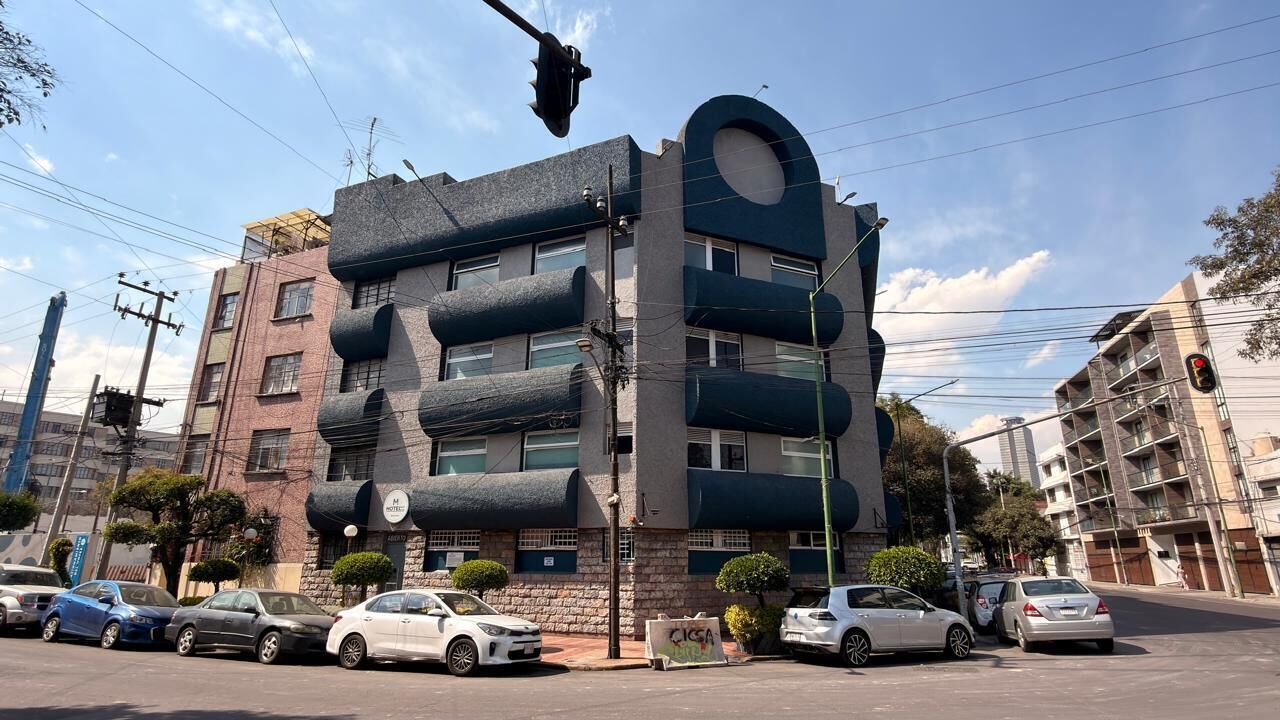 Um edifício de vários andares com um design arquitetônico único, apresentando protuberâncias cilíndricas e um topo arredondado.