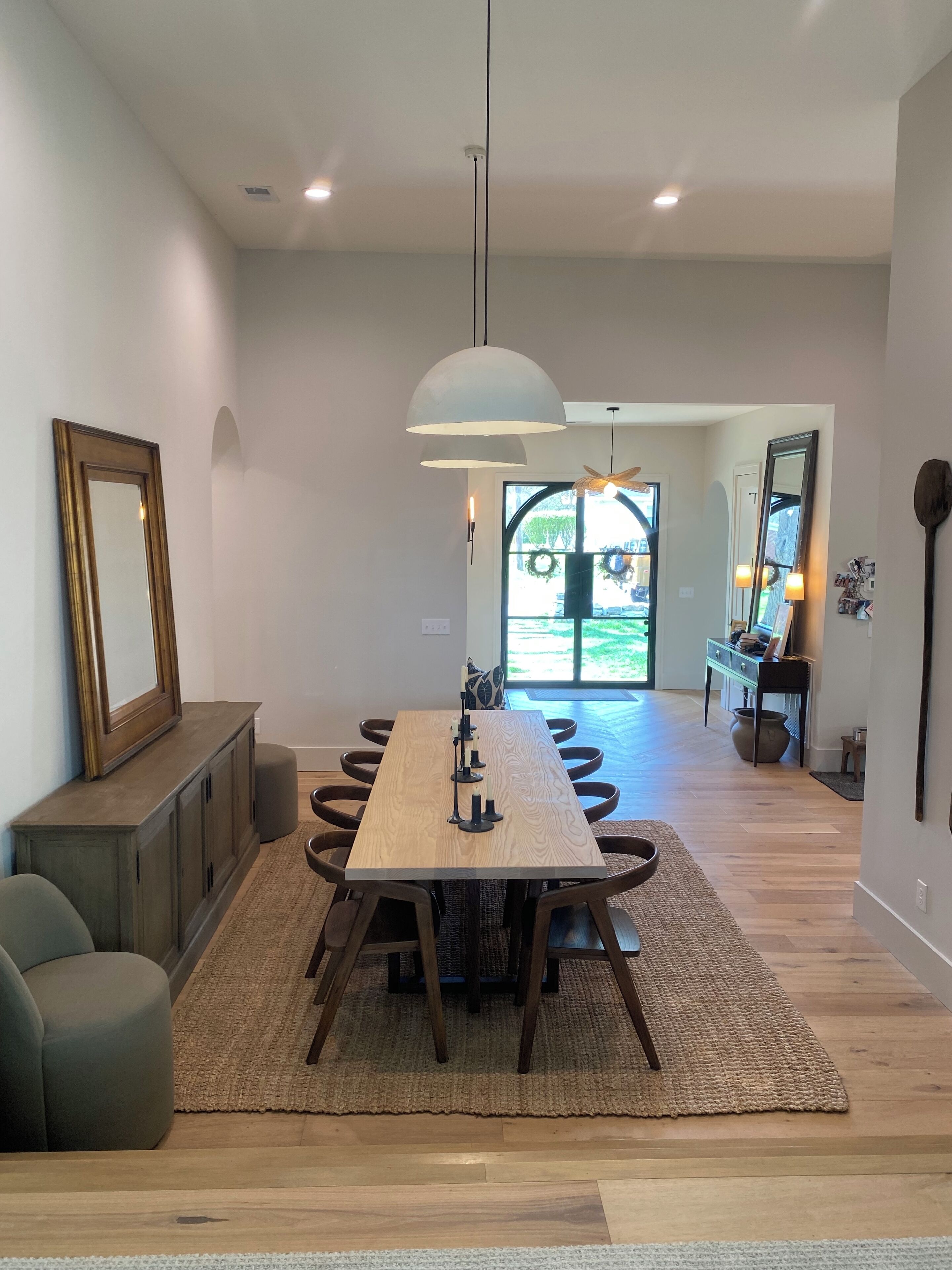 A dining area with a wooden table, chairs, and a hanging light fixture.