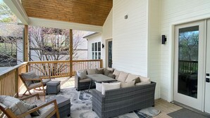 A covered outdoor deck with a ceiling fan, wooden flooring, and a seating area with a sofa and chairs. - Stunning Home in Historic Franklin, TN

Walk to Downtown, pickleball, & coffee! (Franklin)
