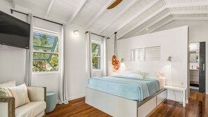A modern bedroom with a bed, a TV, and a view of the outdoors. - OHANA WATA cabana, BEACHFRONT luxury, privacy, view & space IN the village ! (Placencia)
