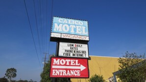A motel sign with a vacancy notice, low daily rates, phone king bed, and free internet. - Calico Motel (Anaheim)