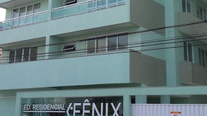 A multi-story residential building with balconies and a garage sign. - Located 150 meters from the most charming beach in Arraial do Cabo, this 2-bedroom apartment features air conditioning! (Arraial do Cabo)