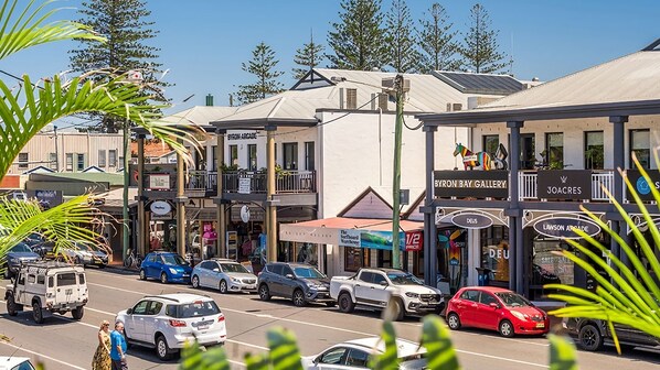 Une vue de rue avec plusieurs devantures de magasins, notamment la galerie Byron Bay et Joacres.