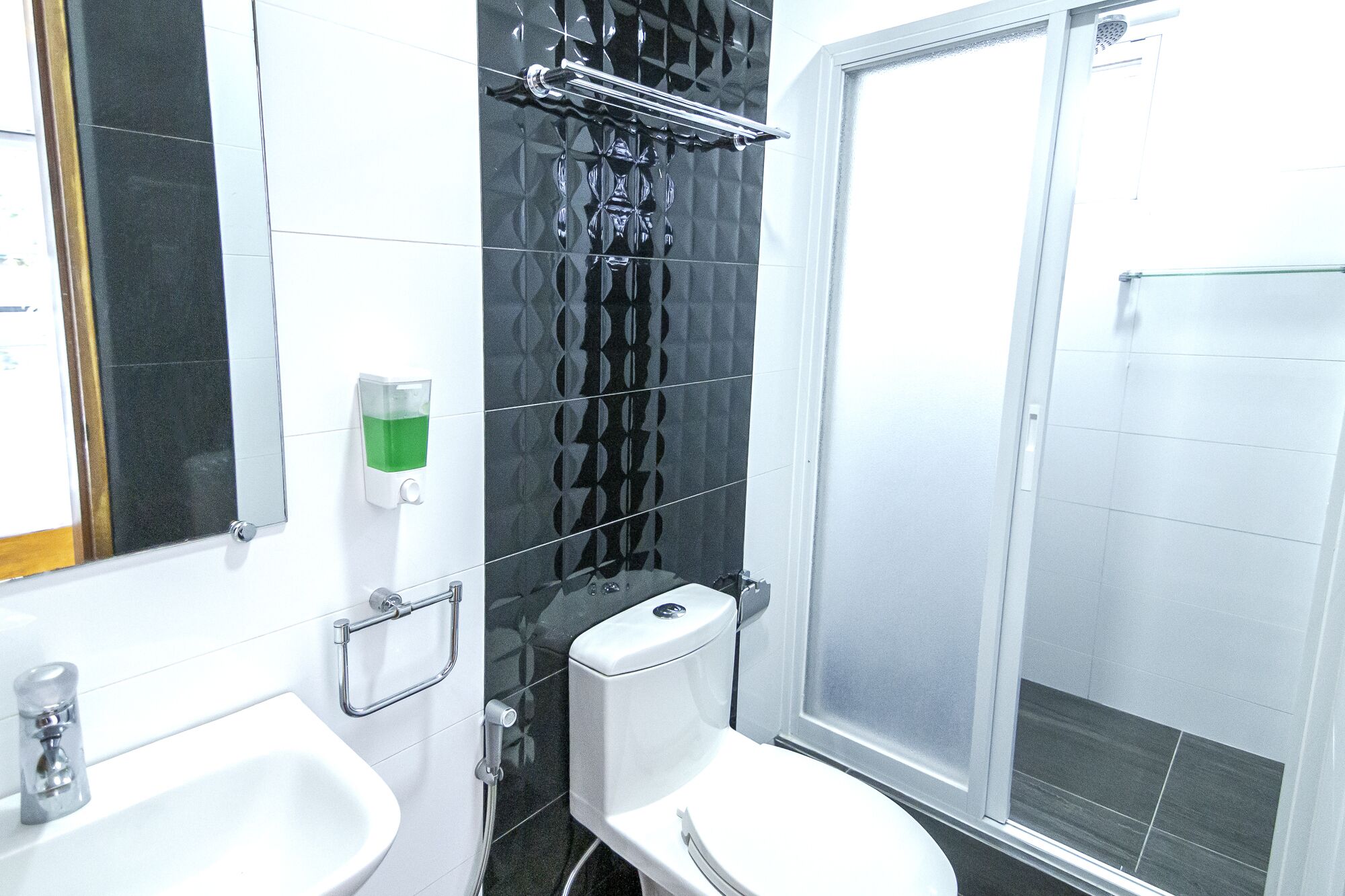 Un baño con inodoro, lavamanos y ducha.