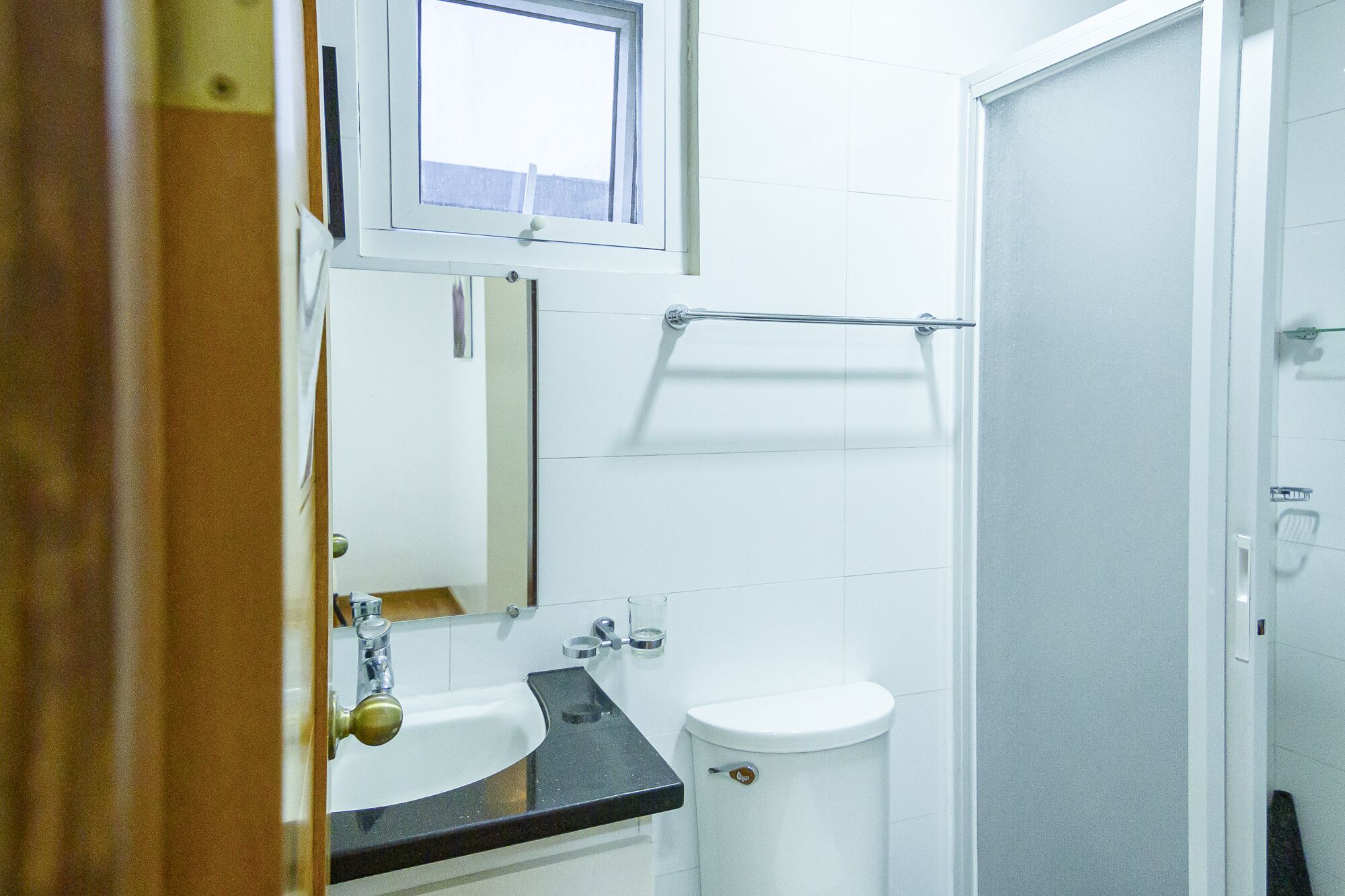 A bathroom with a sink, toilet, and a towel rack.