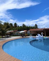 Una piscina al aire libre, camas de piscina gratis, sombrillas
