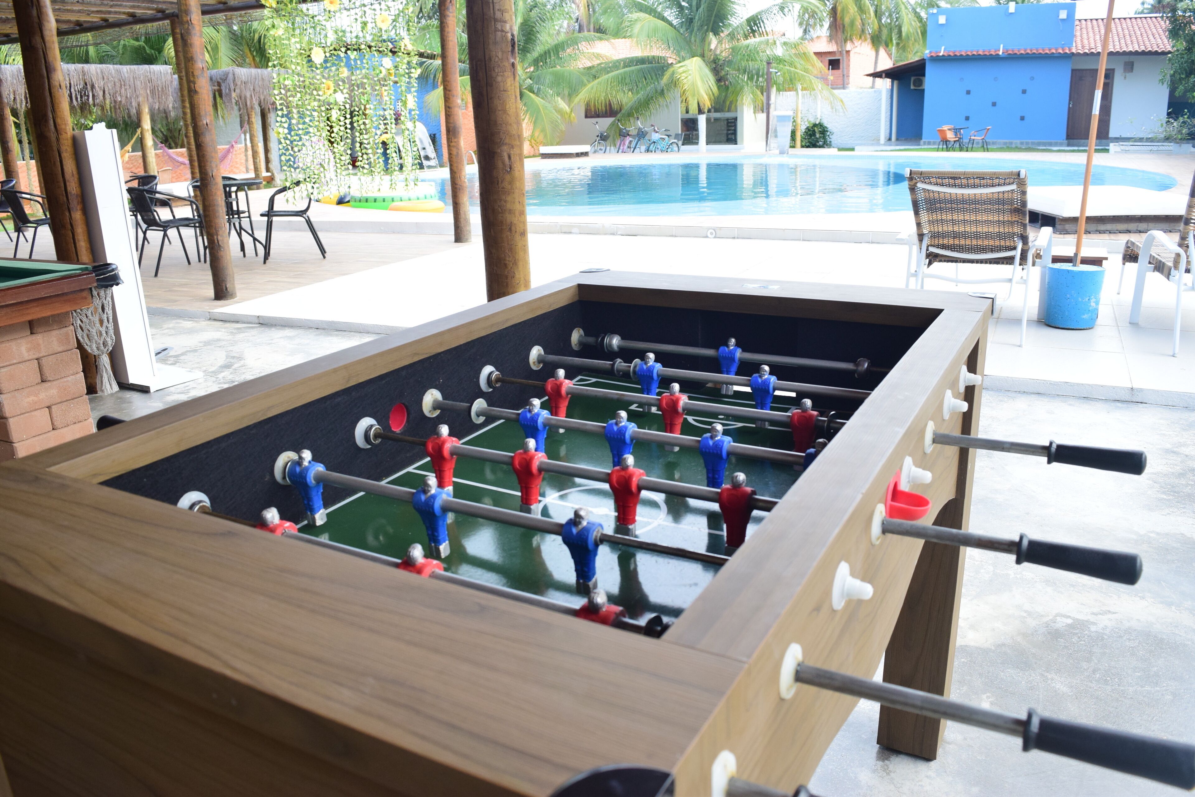 Una mesa de fútbol de mesa con una piscina al fondo.