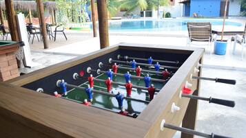 Una mesa de fútbol de mesa con una piscina al fondo.