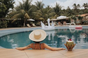 Una piscina al aire libre, camas de piscina gratis, sombrillas