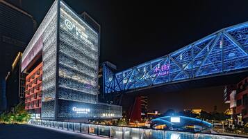 Un edificio moderno con señalización iluminada y una estructura de puente destacada.
