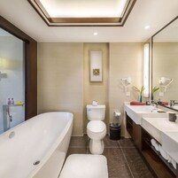 Un baño moderno con una bañera independiente, inodoro y tocador con espejo.