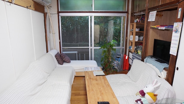 A cozy living room with a sofa, a coffee table, and a plush toy. - Guesthouse & Diving Seacolo (Ishigaki)