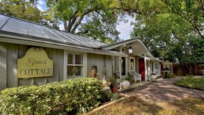 A guest cottage with a sign, a covered porch, and a brick pathway. - Adams Guest Full House, King Williams Area, Southtown (San Antonio)