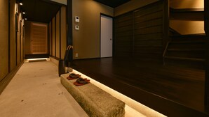 Un couloir avec un banc, une porte et un escalier.