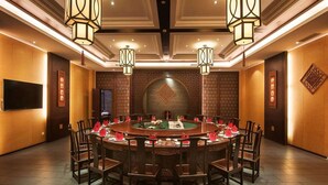 A conference room with a round table, chairs, and a television. - Xitang Yanyu Jiangnan Jinglan Hotel (Jiaxing)