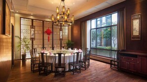 A traditional dining area with a round table, wooden chairs, and a decorative chandelier. - Xitang Yanyu Jiangnan Jinglan Hotel (Jiaxing)