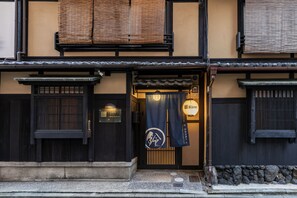A traditional Japanese building with a dark wooden facade, a tiled roof, and a sign that reads "Rinn". - Rinn Shijo Takasegawa North (Kyoto)