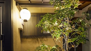 A well-maintained garden with stepping stones, a small tree, and a water feature. - Rinn Tsukinuke (Kyoto)