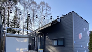 Une maison mobile moderne dotée d’une terrasse en bois, d’un petit porche et d’une allée en gravier.