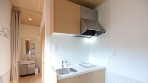 Une cuisine moderne dotée d’un évier à deux bacs, de meubles en bois et d’une hotte en acier inoxydable.