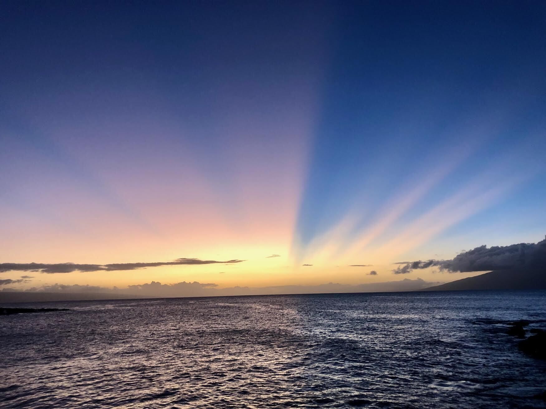 Un coucher de soleil sur une mer calme, avec un horizon dégagé.