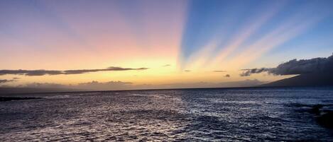 Un coucher de soleil sur une mer calme, avec un horizon dégagé.