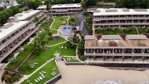 A resort with multiple hotel buildings, a beach, and a pool area.