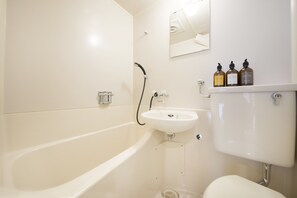 Bañera con ducha, secador de pelo, pantuflas, toallas