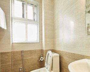 A bathroom with a toilet, bidet, and bathtub.