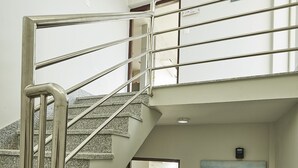 Een modern interieur met een metalen trap, een houten kast en een schilderij aan de muur.