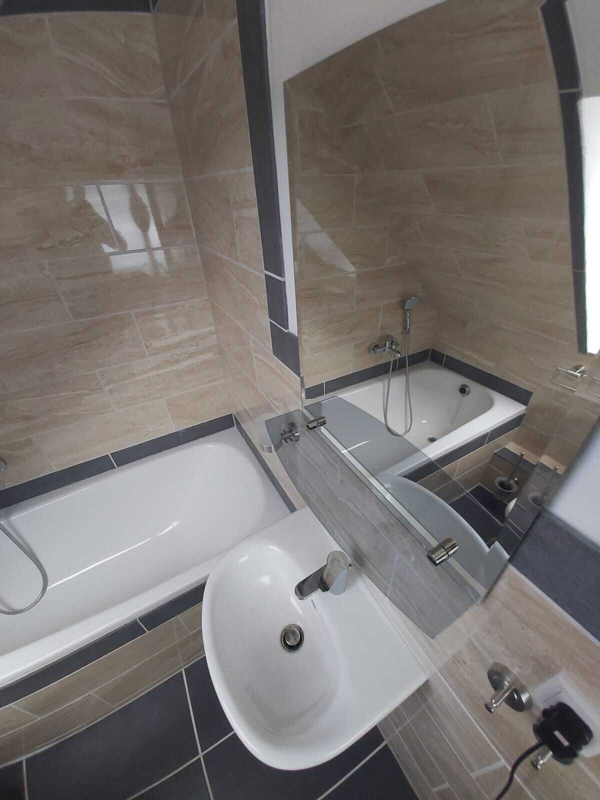 A modern bathroom with a bathtub, a sink, and a shower.
